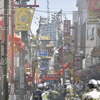 横浜中華街の火災現場付近で、消火活動をする消防隊員ら＝11日午前11時24分、横浜市