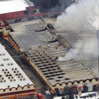 火災があった「三幸製菓」の荒川工場＝12日午前7時44分、新潟県村上市（共同通信社機から）