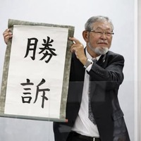 「勝訴」と書かれた垂れ幕を掲げる大阪府泉佐野市側代理人の阿部泰隆弁護士＝10日午後、大阪市