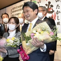 金沢市長選で初当選し、花束を手に笑顔を見せる村山卓氏（手前右）＝13日夜