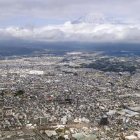 富士山（奥）と静岡県富士宮市の市街地。「富士山火山防災対策協議会」は噴火に備えた避難計画を部分改定する中間報告書を公表した＝30日午後（共同通信社ヘリから）