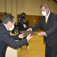 くじ引きで当選が決まり、当選証書を受け取る北山太加視氏（右）＝8日午後、三重県伊賀市