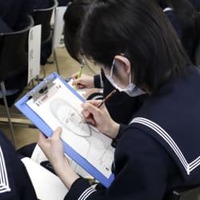 聞き取った情報を基に、捜査用似顔絵を描く高校生＝16日午後、北海道函館市