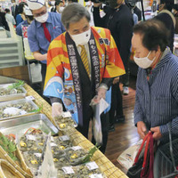 法被を着て鶴屋百貨店の食料品売り場に立ち、熊本県産アサリの購入を勧める蒲島郁夫知事＝17日午前、熊本市