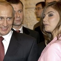 アリーナ・カバエワさん（右）の隣で笑顔を見せるロシアのプーチン大統領＝2004年11月、モスクワのクレムリン（ロイター＝共同）