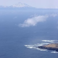 4月30日、北海道・知床半島沖で捜索する漁船団（左下）。奥は国後島（共同通信社ヘリから）
