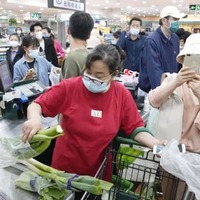 4月25日、北京市内のスーパーで買い出しする市民ら（共同）