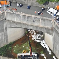 トンネル点検の準備中に、土砂をためる池に転落した作業車＝16日午後2時46分、広島市西区（共同通信社ヘリから）