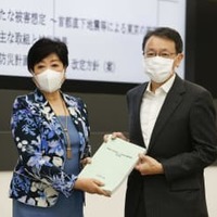 東京都の防災会議で、地震部会長の平田直東京大名誉教授（右）から報告書を受け取る小池百合子知事＝25日午前、東京都庁