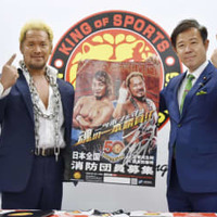 消防団員募集のポスターを手にする新日本プロレスの真壁刀義選手（左）と田畑裕明総務副大臣＝1日午後、東京都中野区