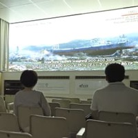 閉館の日を迎えた津波体験館で映像を見る来館者＝26日午後、宮城県気仙沼市
