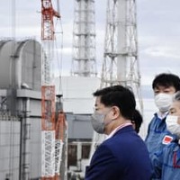 東京電力福島第1原発を視察する松野官房長官（左）＝16日午前（代表撮影）