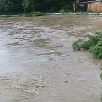 大雨で増水した長崎県対馬市の佐護川＝18日午後3時30分ごろ（長崎県提供）