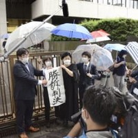 「1型糖尿病」訴訟の判決後、「勝訴判決」の紙を掲げる原告ら＝26日午前、東京地裁