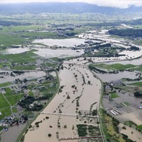 大雨の影響で増水した、山形県の南陽市（右側）と川西町を流れる最上川＝4日午後2時10分（共同通信社機から）