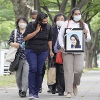 ウィシュマ・サンダマリさんの遺影を手に、検察審査会に審査申し立てに向かう妹のポールニマさん（右）ら＝8日午後、名古屋市