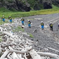 知床半島の海岸で行方不明者を捜索する警察官ら＝18日午後、北海道斜里町（北海道警提供）