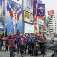 大阪・ミナミの名所、グリコの看板前でポーズを取る訪日観光客ら＝2019年4月