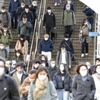 マスク姿で通勤する人たち＝3月、東京都港区