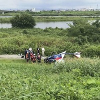 墜落した超軽量飛行機を調べる警察官ら＝10日午前10時49分、群馬県玉村町