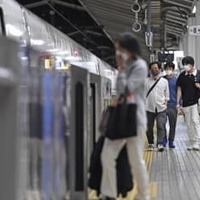 「列車ホテル」として開放された新幹線の車両に乗り込む人たち＝24日午前0時40分、JR東京駅