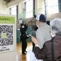 東北電力女川原発での重大事故を想定した防災訓練で、避難支援のスマートフォンアプリを使う住民ら＝29日午前、宮城県大崎市