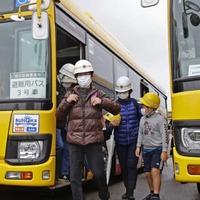 桜島の大規模噴火を想定した訓練で、避難用のバスから降りる参加者＝19日午前、鹿児島市