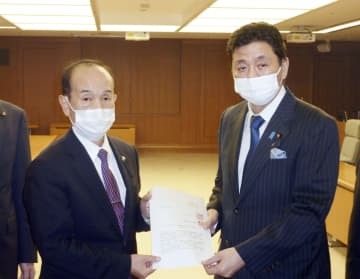 岸防衛相（右）に要請書を手渡す青森県三沢市の小檜山吉紀市長＝8日午後、防衛省