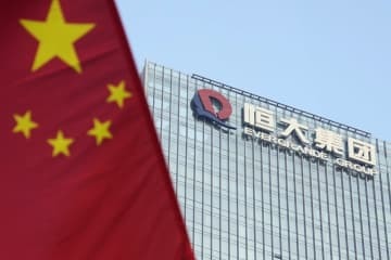 中国恒大集団の本社が入るビル。左はビル前の通りに掲げられた中国国旗＝9月、中国広東省深☆（土ヘンに川）市（共同）