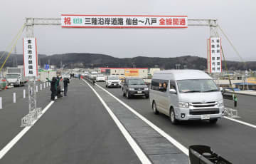 三陸沿岸道路の全線開通を祝い、通り初めを行う関係車両＝18日午後、岩手県久慈市