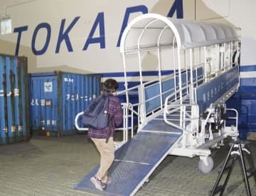 鹿児島県十島村の悪石島に向かうフェリーに乗り込む松下まゆみさん＝22日夜、鹿児島港