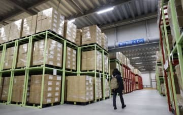 山積みになって倉庫に保管されている布製の「アベノマスク」が入った段ボール箱＝22日午前、東京近郊
