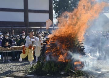 成田山新勝寺の「納め札お焚き上げ」で、お札を「智慧の火炎」に投げ入れる山伏姿の僧侶＝28日午前、千葉県成田市