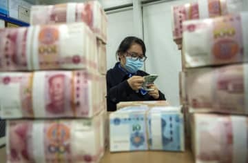 中国・江蘇省の銀行で紙幣を数える行員＝6日（AP＝共同）