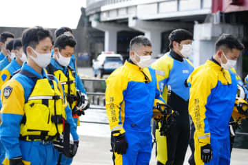 行方不明者の捜索前に、黙とうする静岡県警の警察官＝3日午前9時56分、静岡県熱海市