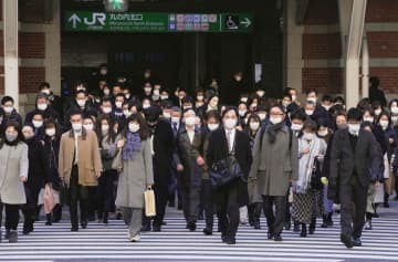 仕事始めを迎え、マスク姿で通勤する人たち＝4日午前、JR東京駅前