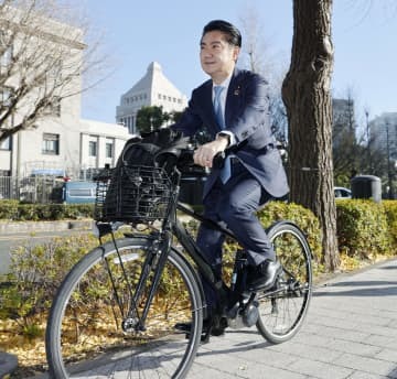 自転車で自民党本部に向かう山下貴司元法相＝2021年12月、東京・永田町