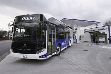 燃料電池で動く通勤用のバス。右奥は水素ステーション＝13日午前、愛知県刈谷市