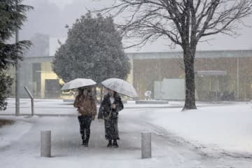 雪が降る金沢市内を歩く人たち＝13日午後4時43分