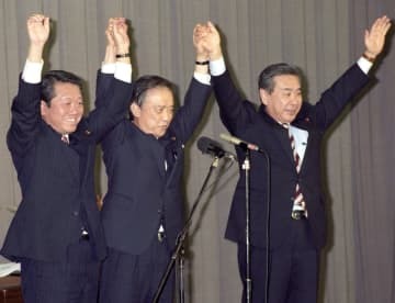 1995年12月、新進党の党首に就任し万歳をする小沢氏（左）。中央は海部氏、右は羽田氏＝国会