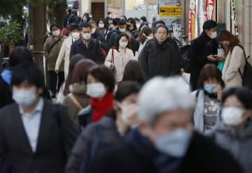 マスク姿で東京・新橋を歩く人たち＝18日午後