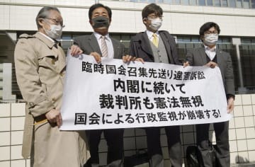 臨時国会召集訴訟の控訴審判決後に、「内閣に続いて裁判所も憲法無視」などと書かれた横断幕を掲げる原告側の弁護士ら＝27日午後、岡山市