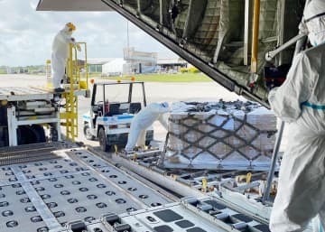 トンガのファアモツ国際空港で、航空自衛隊のC130輸送機から降ろされる支援物資＝29日（防衛省統合幕僚監部提供）