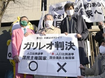 衆院選の「1票の格差」訴訟の判決を受け、東京高裁前で「ガリレオ判決」と書かれた紙を掲げる升永英俊弁護士（中央）ら＝2日午後