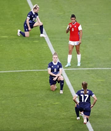 東京五輪サッカー女子の試合前のピッチで、人種差別に抗議し片膝をつく英国代表の選手ら＝2021年7月、札幌ドーム