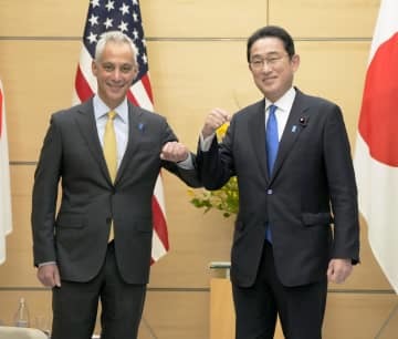 米国のラーム・エマニュエル新駐日大使（左）とタッチする岸田首相＝4日午前、首相官邸