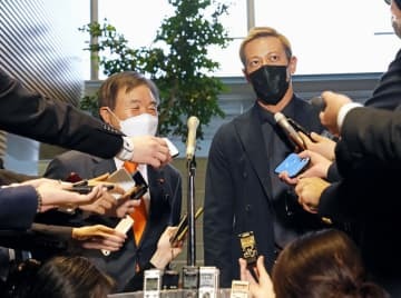 首相官邸で取材に応じる本田圭佑選手。左は自民党の遠藤選対委員長＝4日午後