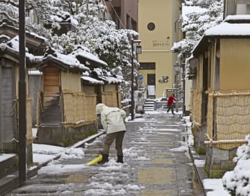 金沢市の中心部、長町武家屋敷跡周辺で除雪をする人＝5日午前