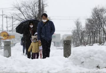 大雪が降り続く中、滋賀県米原市を歩く人たち＝6日午後