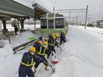 JR平和駅で除雪作業する社員ら＝8日、札幌市（JR北海道提供）